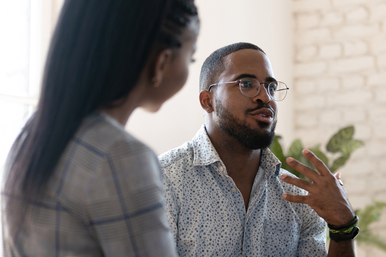 Excited african American man in glasses sit in circle at team therapy session talking sharing thoughts or ideas, motivated biracial male counseling diverse people at group psychotherapy treatment